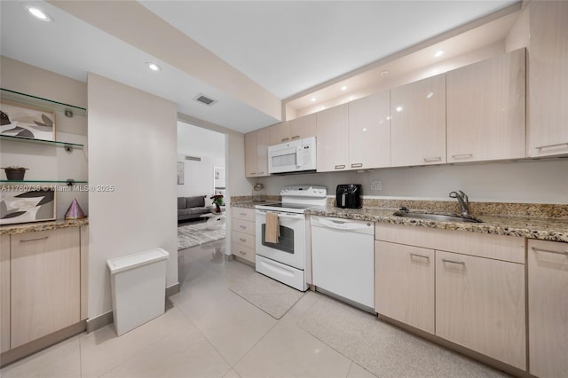 kitchen featuring white appliances, light stone counters, visible vents, recessed lighting, and a sink