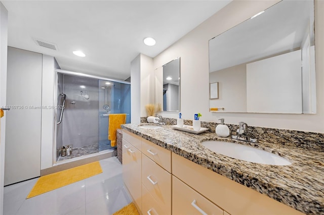 bathroom with a shower stall, double vanity, visible vents, and a sink