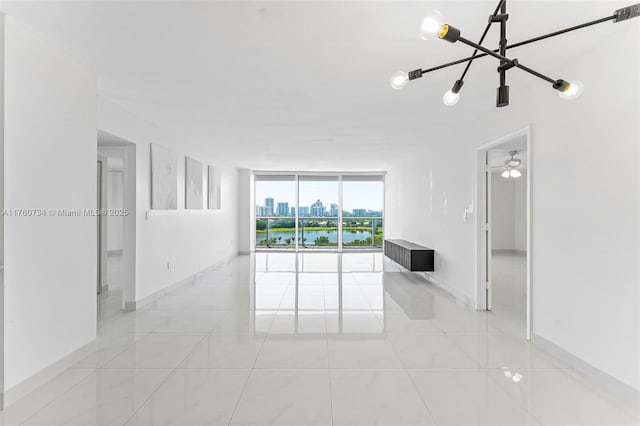 unfurnished room featuring expansive windows, baseboards, a city view, and light tile patterned flooring