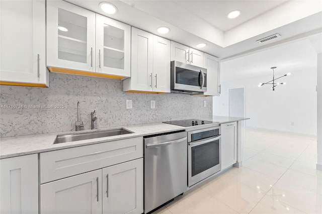 kitchen with a sink, stainless steel appliances, visible vents, and white cabinets