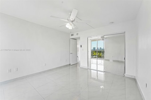 empty room featuring visible vents, baseboards, and a ceiling fan