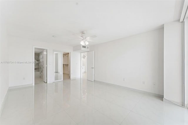 unfurnished bedroom with a spacious closet, visible vents, ceiling fan, baseboards, and a closet