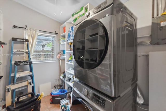 laundry area with tile patterned floors, laundry area, and stacked washer / drying machine