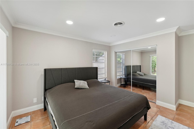 bedroom with crown molding, visible vents, baseboards, and a closet