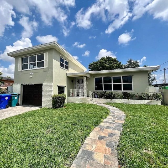 tri-level home with a front lawn, a garage, brick siding, and stucco siding