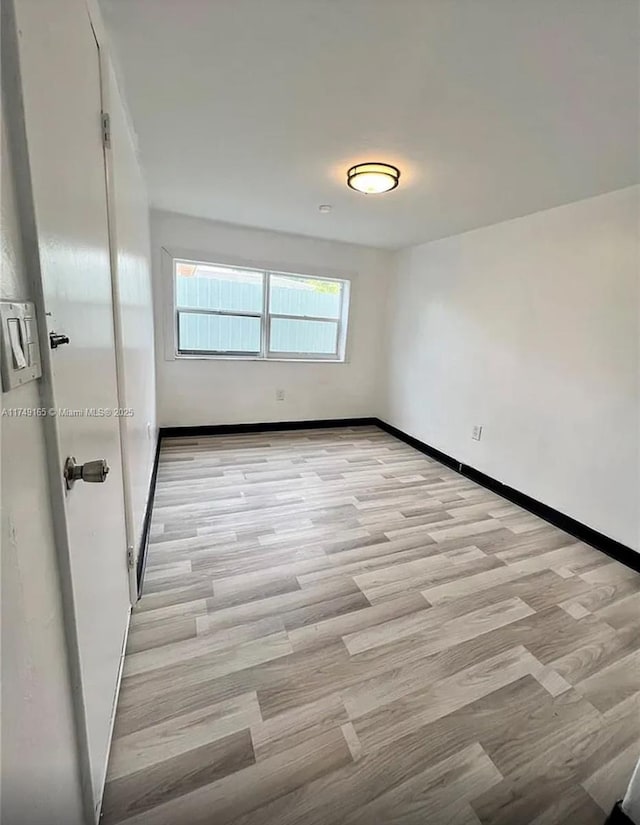 unfurnished room featuring light wood-style flooring and baseboards