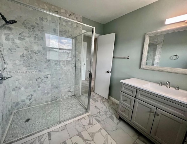 full bathroom with vanity, a shower stall, baseboards, and marble finish floor