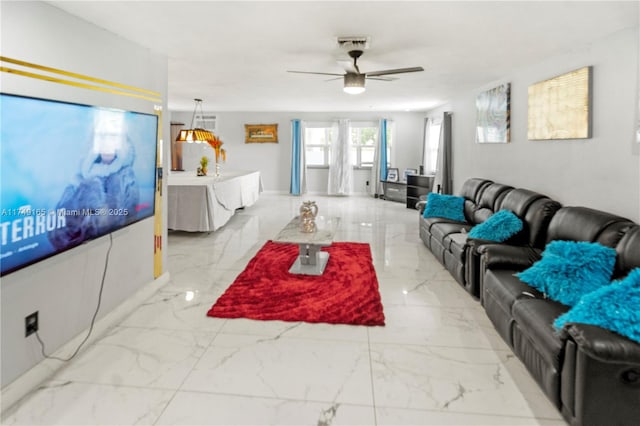 living area featuring marble finish floor and ceiling fan