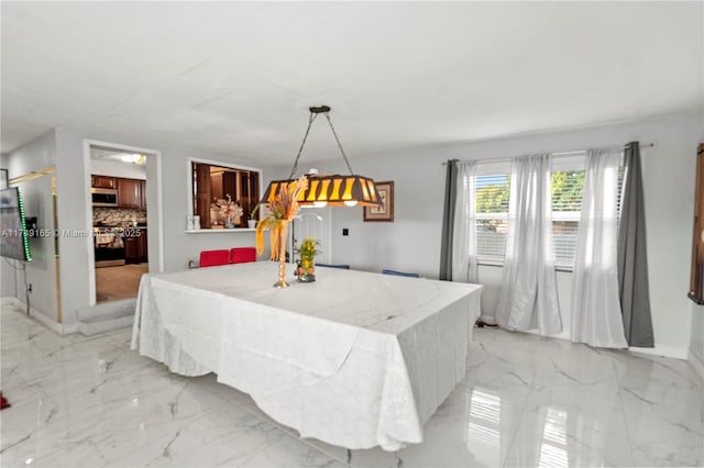 dining space with baseboards and marble finish floor