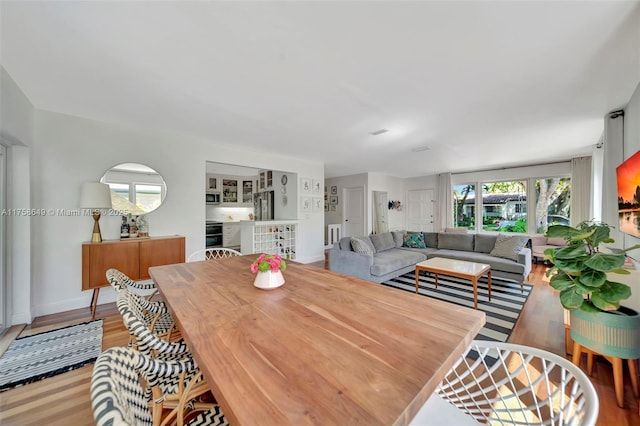 dining space with baseboards and wood finished floors