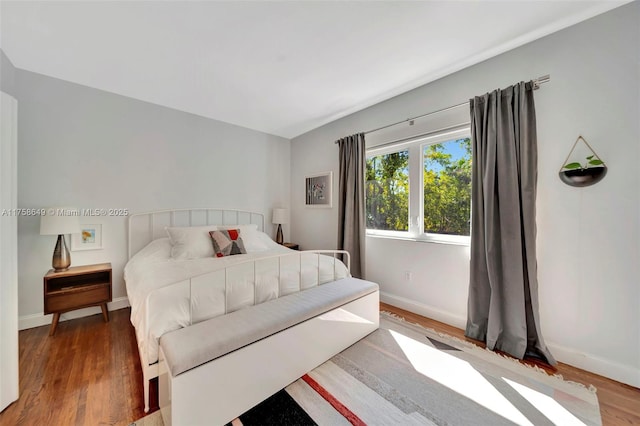 bedroom featuring wood finished floors and baseboards