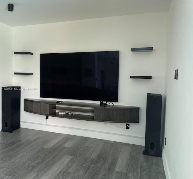 living area with baseboards and wood finished floors