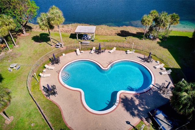 pool with a patio, a yard, and fence