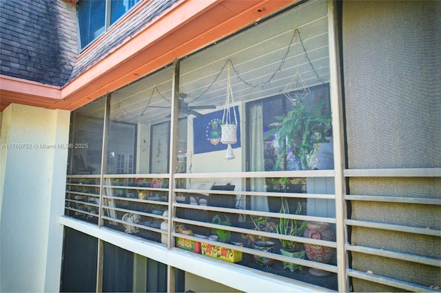 exterior space featuring mansard roof and a shingled roof