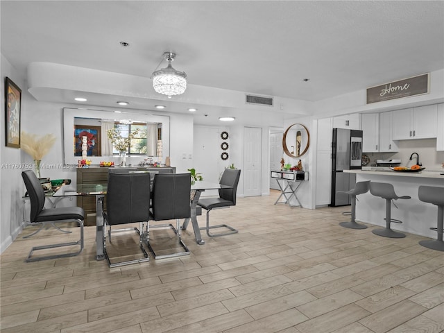 dining space featuring light wood-style floors and visible vents