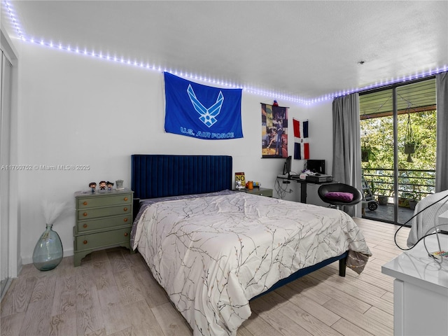 bedroom featuring access to outside and light wood finished floors