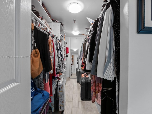 walk in closet with light wood-style flooring