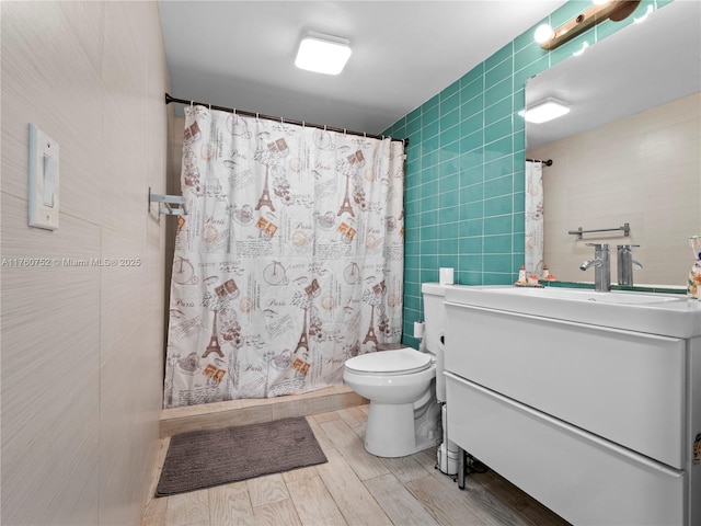 full bath with toilet, vanity, a shower with curtain, wood finished floors, and tile walls