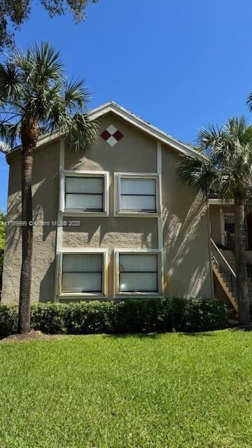 view of home's exterior featuring stucco siding and a yard