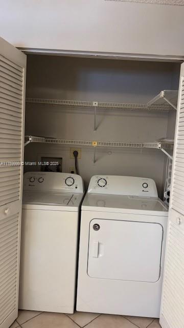 laundry room with separate washer and dryer, light tile patterned flooring, and laundry area