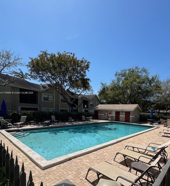 pool with a patio and fence