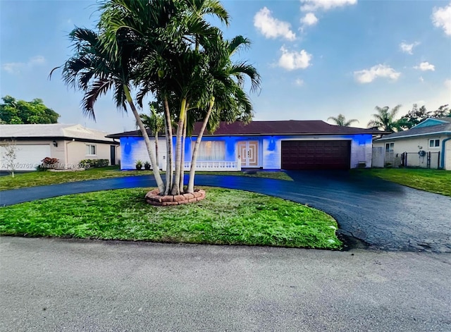 ranch-style house with driveway, a front yard, and fence