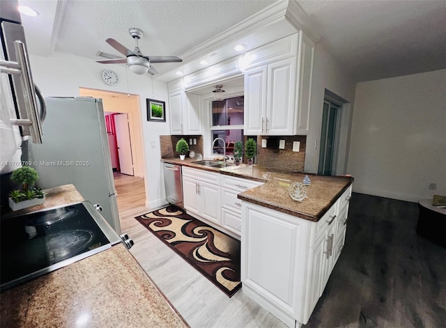 kitchen featuring electric range, a sink, white cabinets, light wood-style floors, and dishwasher