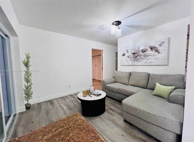 living area featuring visible vents, baseboards, and wood finished floors