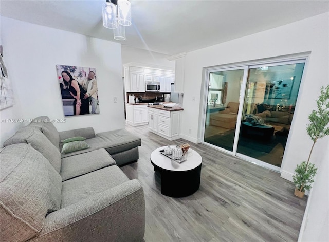 living area featuring light wood-style flooring and baseboards