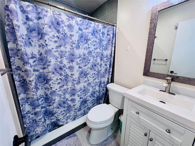 bathroom featuring vanity, curtained shower, and toilet