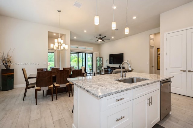 kitchen featuring visible vents, a kitchen island with sink, a sink, stainless steel dishwasher, and light wood-style floors