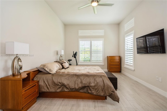 bedroom with light wood-style floors, baseboards, and ceiling fan