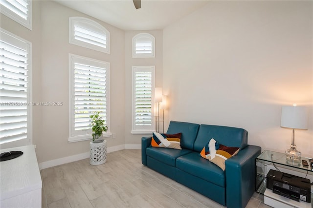 living area featuring wood finished floors, a healthy amount of sunlight, and baseboards