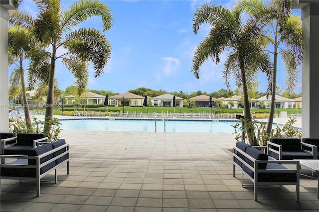 community pool with a residential view, a patio, and fence