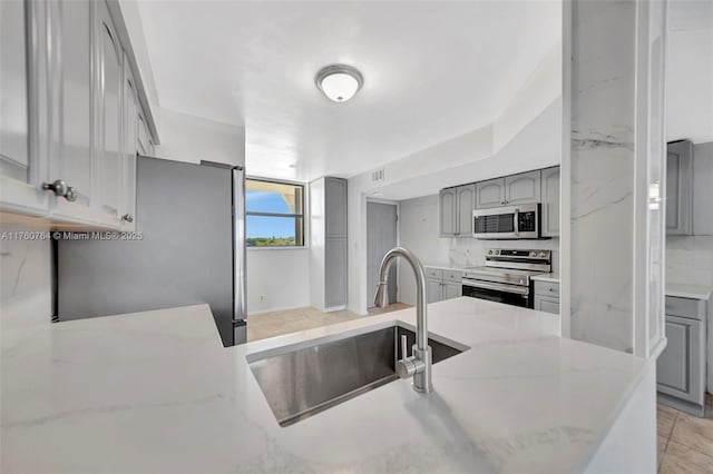 117 Lake Emerald Dr Unit 408, Oakland Park, FL 33309 - kitchen featuring stainless steel appliances, a sink, gray cabinetry, and light stone countertops