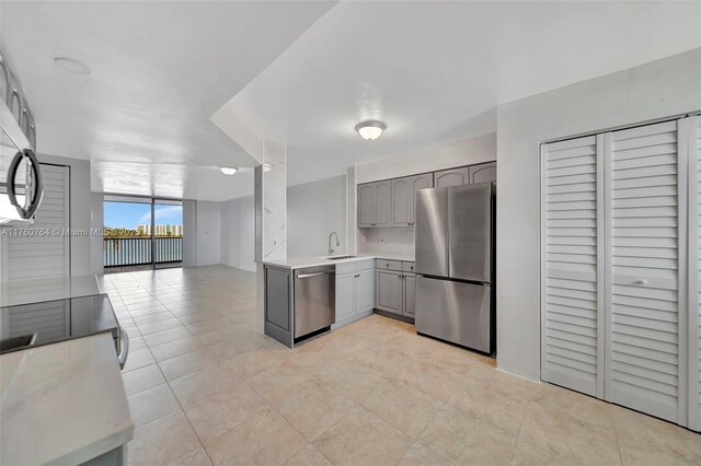 117 Lake Emerald Dr Unit 408, Oakland Park, FL 33309 - kitchen featuring appliances with stainless steel finishes, gray cabinets, light countertops, light tile patterned floors, and a sink