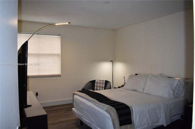 bedroom featuring baseboards and wood finished floors