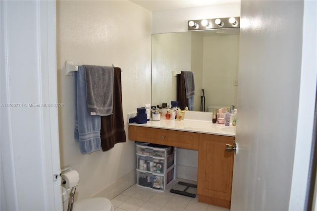 half bathroom featuring vanity, tile patterned floors, and toilet