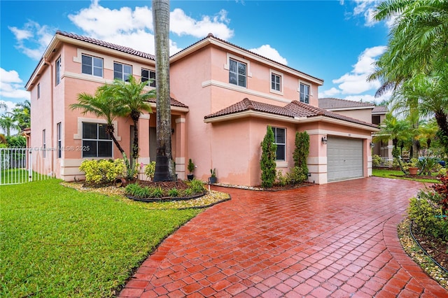 mediterranean / spanish home featuring a front yard, fence, stucco siding, a garage, and decorative driveway