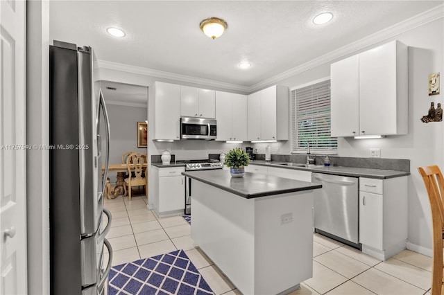 kitchen with a sink, dark countertops, stainless steel appliances, crown molding, and light tile patterned floors