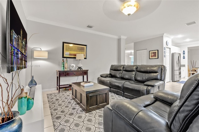 living area with tile patterned floors, visible vents, ornamental molding, and a ceiling fan