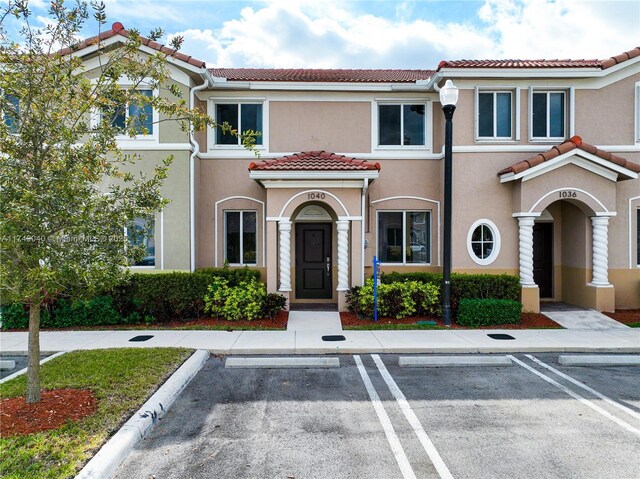 1040 SE 24th Ave, Homestead, FL 33035 - view of front of house with a tiled roof, uncovered parking, and stucco siding