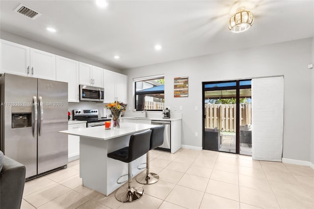 kitchen featuring visible vents, light countertops, white cabinets, a sink, and appliances with stainless steel finishes