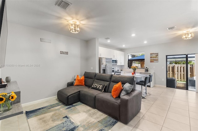 living room with baseboards, visible vents, light tile patterned floors, and an inviting chandelier
