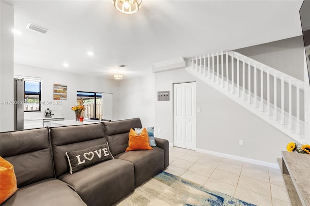 living room featuring visible vents, baseboards, stairway, recessed lighting, and light tile patterned floors