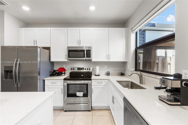 kitchen featuring white cabinetry, appliances with stainless steel finishes, a sink, and visible vents