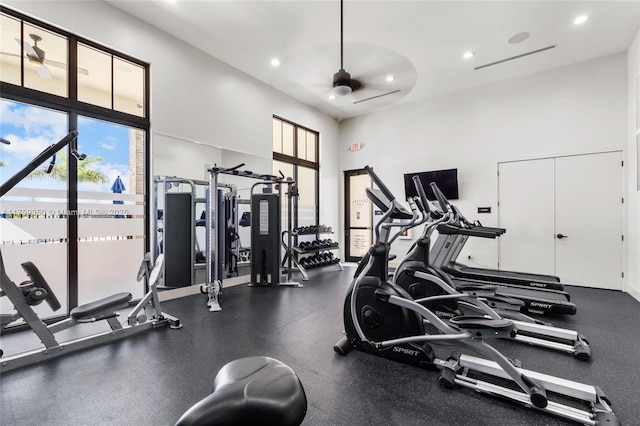 gym with recessed lighting, ceiling fan, and a high ceiling