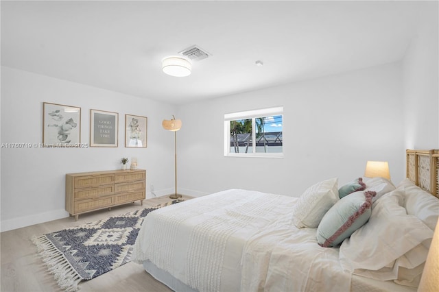 bedroom featuring visible vents, wood finished floors, and baseboards
