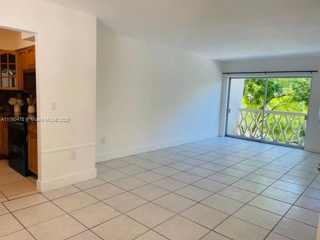 empty room with light tile patterned floors and baseboards