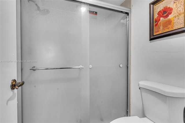 full bathroom with a shower stall and toilet